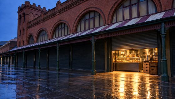 The market roller door half raised at dawn